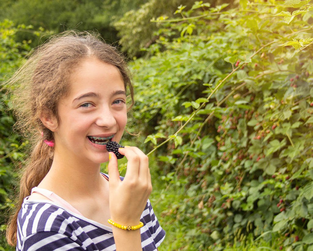Mädchen, das frische Brombeere isst